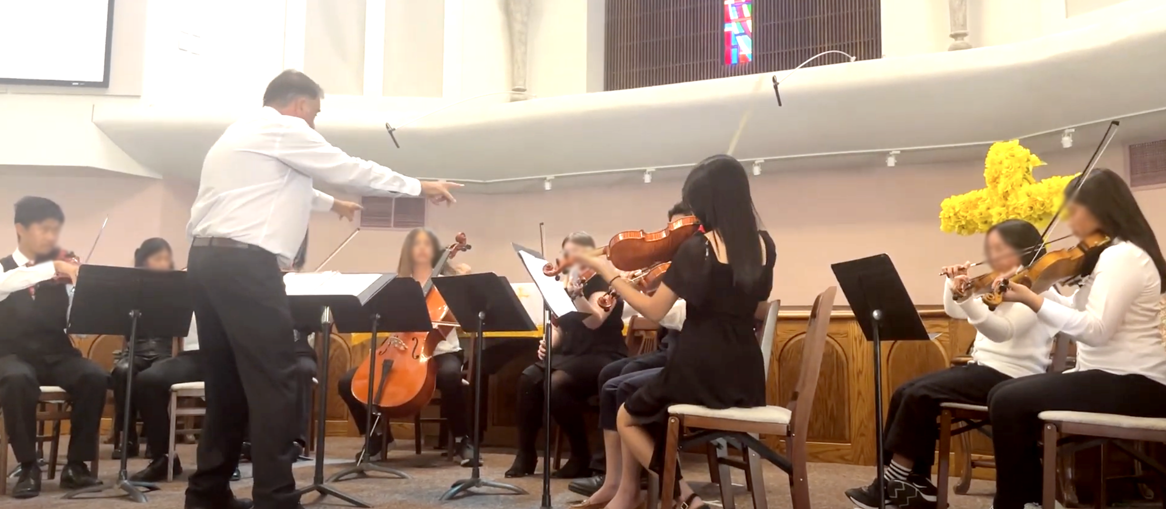 Junior orchestra rehearses with conductor